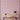 Pink and white striped wallpaper with a repeating red and green floral motif, shown in a styled room setting behind a light wood desk and chair.